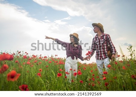 Loving relationship. man and woman in poppy flower field. summer vacation. happy family. country music. spring nature beauty. love and romance. romantic relationship. couple in love with guitar Royalty-Free Stock Photo #2141392569