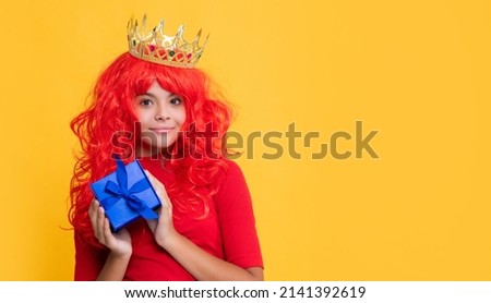 child smile in crown with gift box on yellow background