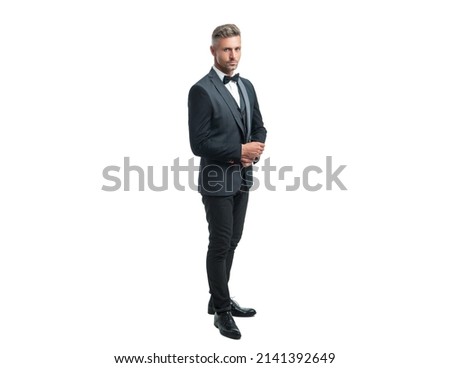 ambitious businessman in tuxedo suit with neck bow isolated on white background. full length Royalty-Free Stock Photo #2141392649