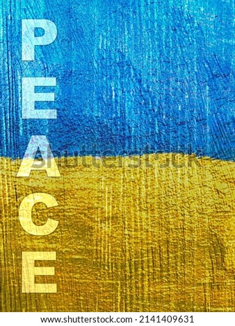 Stand with Ukraine: word Peace on Ukrainian flag painted on wooden wall