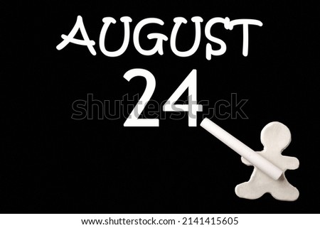24th day of August. A small white plasticine man writing the date 24 August on a black board. Business concept. Education concept. Summer month, day of the year concept.