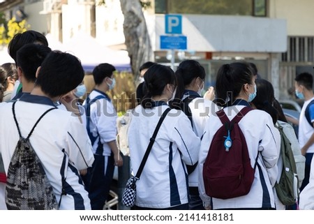 back view of group of boy and girl high or middle- school students in white uniform with face mask and bags in Hong Kong Royalty-Free Stock Photo #2141418181