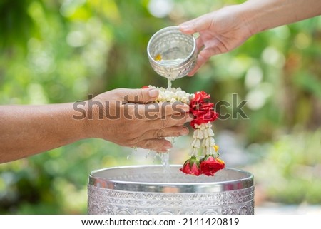 Pouring water on hands of seniors and gives blessings, (Songkran holiday Thailand) Royalty-Free Stock Photo #2141420819