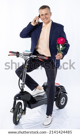 a man in a suit and shirt on an electric car, a tricycle. isolated white background. office manager rides around the city, hurries to work, a date. eco-friendly transport. Earth Day