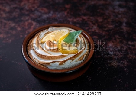 Traditional french lemon tart on a dark rusty table. close-up shot. View from above