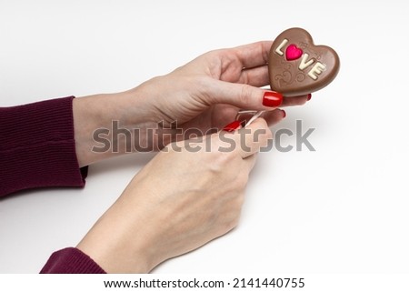 woman holding a chocolate candy in the form of a heart. High quality photo