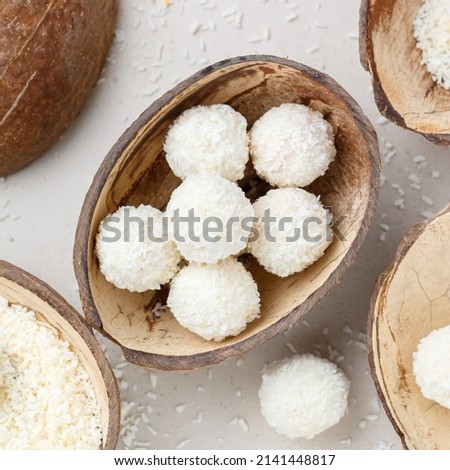 Homemade round candies made of coconut and white chocolate. Preparation of a delicious healthy dessert. Raffaello. Selective focus, top view, square picture