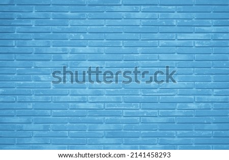 Brick wall painted with blue dark paint pastel calm tone texture background. Brickwork and stonework flooring interior rock old pattern clean concrete grid uneven bricks design stack backdrop.