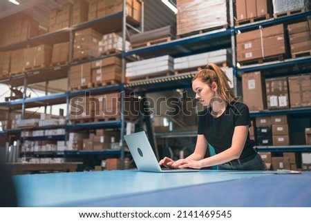 Woman using laptop at warehouse
 Royalty-Free Stock Photo #2141469545