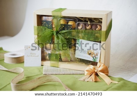 Ramadhan Hampers moslem theme for celebrate the holy, bake snack, nastar, bakery, cookies, pudding, choco chips, roll cake, castangel.with greeting card and green accessories on white background Royalty-Free Stock Photo #2141470493