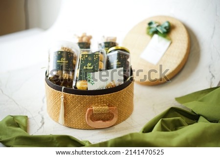 Ramadhan gift. Hampers moslem theme for celebrete the holy, bake snack, nastar, bakery, cookies, pudiing, chococips, roll cake, castangel.with greeting card and green accessories on white background Royalty-Free Stock Photo #2141470525