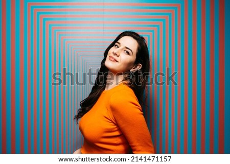 Portrait of brunette caucasian young woman with long hair, against a psychedelic background
