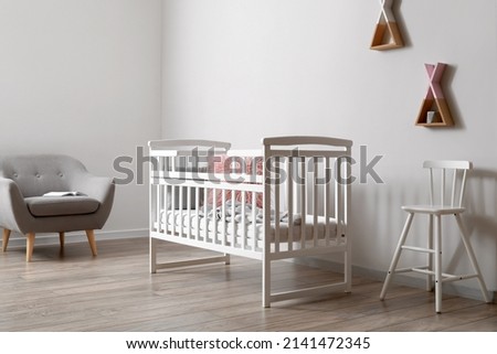 Interior of modern children's room with crib Royalty-Free Stock Photo #2141472345