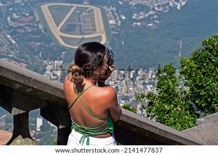 Young brazilian woman photographing the panoramic view of Rio