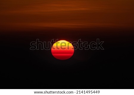 A beautiful sunrise picture with sun appearing as a yolk in the sky.