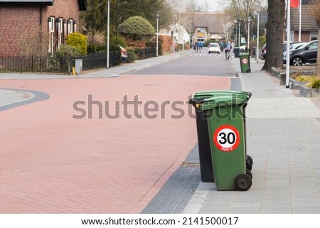 Garbage container on the street with a speed limiting road sign of up to 30 km per hour, which reads "Thank you" (Dutch: Dank U).