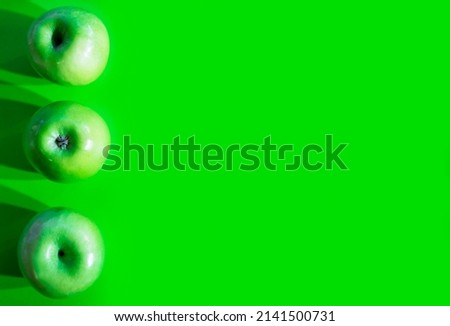 Three Fresh green apples isolated on green background with lot of copy space for text