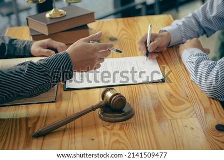 The client is explaining the offense to a lawyer and working together to resolve the offense. Concepts of litigation and justice in the Office of Legal Counsel to punish defendants in the courtroom. Royalty-Free Stock Photo #2141509477