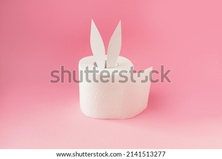 Bunny ears out of white toilet paper roll on pastel pink background. Easter coronavirus trendy rabbit concept. Side view, place for text, banner. High quality photo