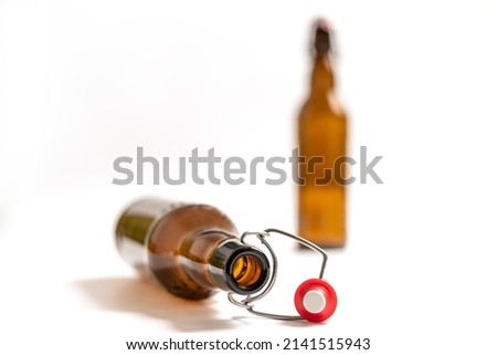 Empty beer bottle with swing top or flip top cork lying on white background. Artistic view, very shallow focus