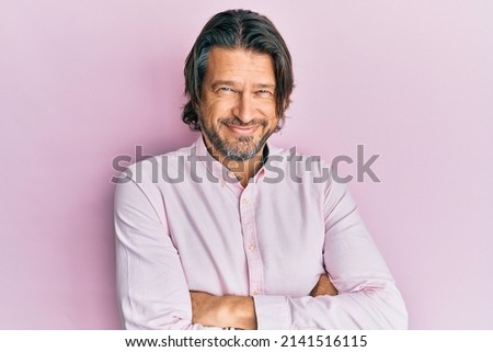 Middle age handsome man wearing business shirt happy face smiling with crossed arms looking at the camera. positive person. 