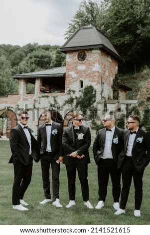 Handsome, stylish groomsmen and groom posing outdoors Royalty-Free Stock Photo #2141521615