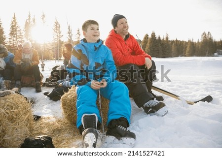 Father and son lacing up ice skates
