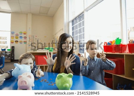 Portrait of teacher with kids counting on fingers Royalty-Free Stock Photo #2141528945