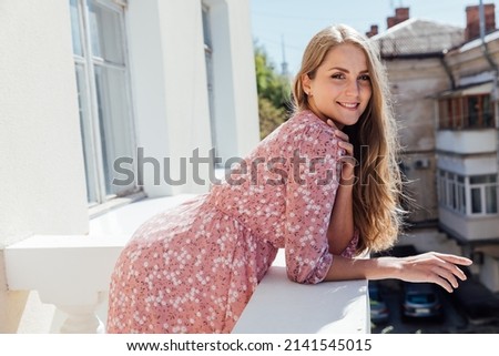 blonde woman in a summer pink dress with flowers