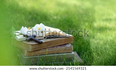 Christian religion background. biblical books, Christian cross and flowers in garden. Symbol of Christian Church. Lent, Faith in God, holy Trinity, Pentecost, religion, Easter, Ascension Day concept