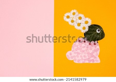 cute rabbit made of flowers and leaves on paper, flat lay, creative easter design, easter natural bunny on pink orange background