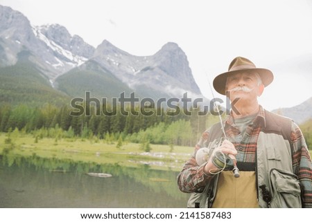 Older man fishing in still lake