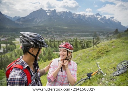 Couple with mountain bikes on hillside