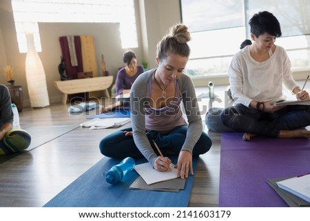 Women with journals at restorative yoga retreat Royalty-Free Stock Photo #2141603179