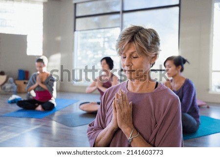 Serene women meditating in yoga class