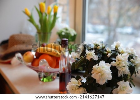 Flowers on the table close-up on a blurred background of a vase of fruit and a bottle of whiskey holiday concept art photo