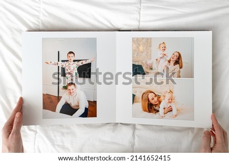 hands with Photobook of family at home on a white background. Photobook is gift. professional photographer and designer. printing of photos and journals in photo laboratory