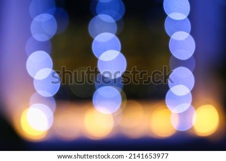 Blue garland on the window blurred in bokeh. Blurred Christmas background.