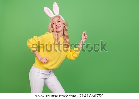 Photo of funky young blond lady dance look promo wear ears yellow pullover pants isolated on green color background