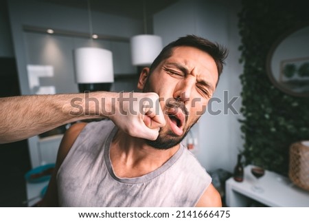 Man takes hard punch in the face. Two man fighting. Man hitting man in the face with fist. Conflict and violence Royalty-Free Stock Photo #2141666475