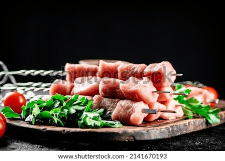 Fresh raw pork kebab on a cutting board. On a black background. High quality photo