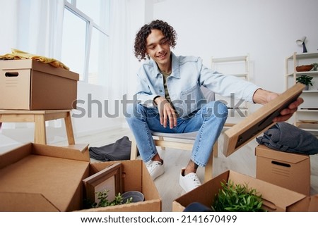 portrait of a man cardboard boxes in the room unpacking headphones Lifestyle Royalty-Free Stock Photo #2141670499