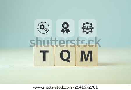 Total quality management (TQM) concept, TQM on wooden cubes with symbols on smart background, copy space. Management approach to long-term success through customer satisfaction and sustainability. Royalty-Free Stock Photo #2141672781