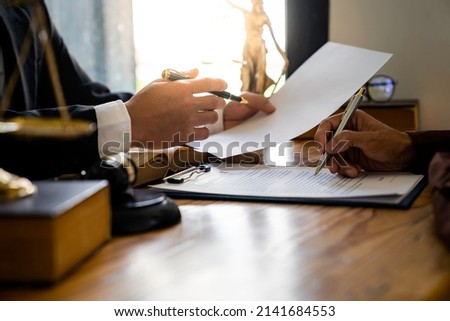 Attorneys or lawyers who are reading the statute of limitations Consultation between male lawyers and business clients, tax and legal and legal services firms. Royalty-Free Stock Photo #2141684553