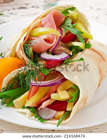 Fresh tortilla wraps with meat and vegetables on plate