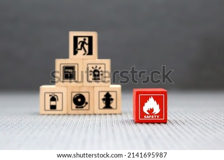 Cube wooden block stack with fire icon and door exit sing or fire escape with prevent icon and fire extinguisher and emergency prevention or protection symbol for safety and rescue.