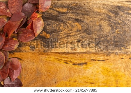 Autumn leaves on wooden background with copy space.