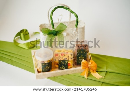 Ramadhan gift. Hampers moslem theme for celebrete the holy, bake snack, nastar, bakery, cookies, pudiing, chococips, roll cake, castangel.with greeting card and green accessories on white background Royalty-Free Stock Photo #2141705245