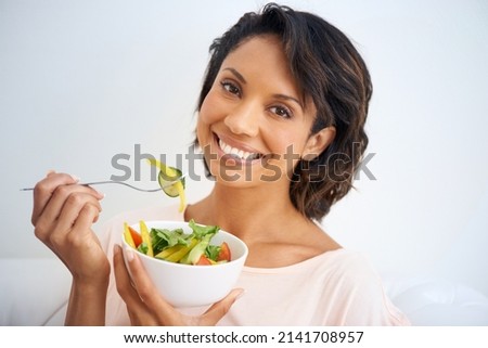 Feeling good starts with eating right. Portrait of a young woman enjoying a salad at home. Royalty-Free Stock Photo #2141708957