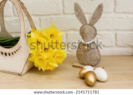 Colorful Easter eggs on the table. Easter bunny. Yellow flowers in a basket. mockup.